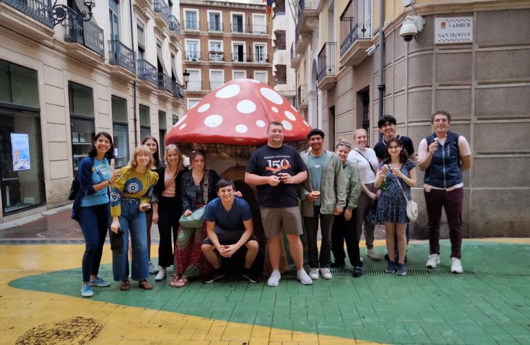 Students take picture with a big mushroom statue