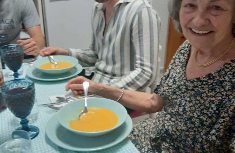 host family enjoying soup and wine together